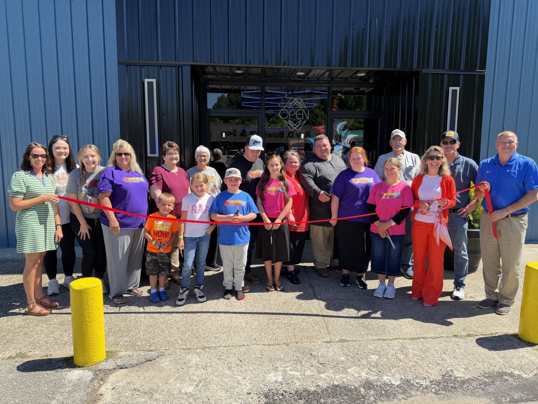 Chamber members, families and business owners cutting the ribbon at a new member business in Clay County